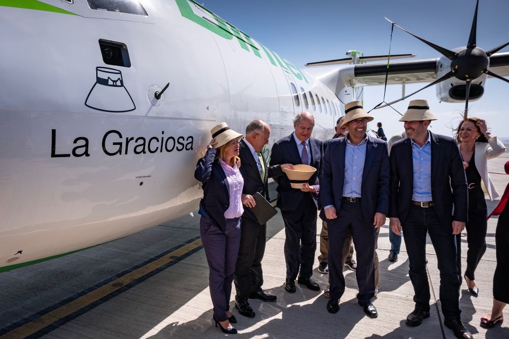 Políticos y directivos de Binter bromean con el sombrero típico del campesino lanzaroteño junto al avión bautizado como "La Graciosa".