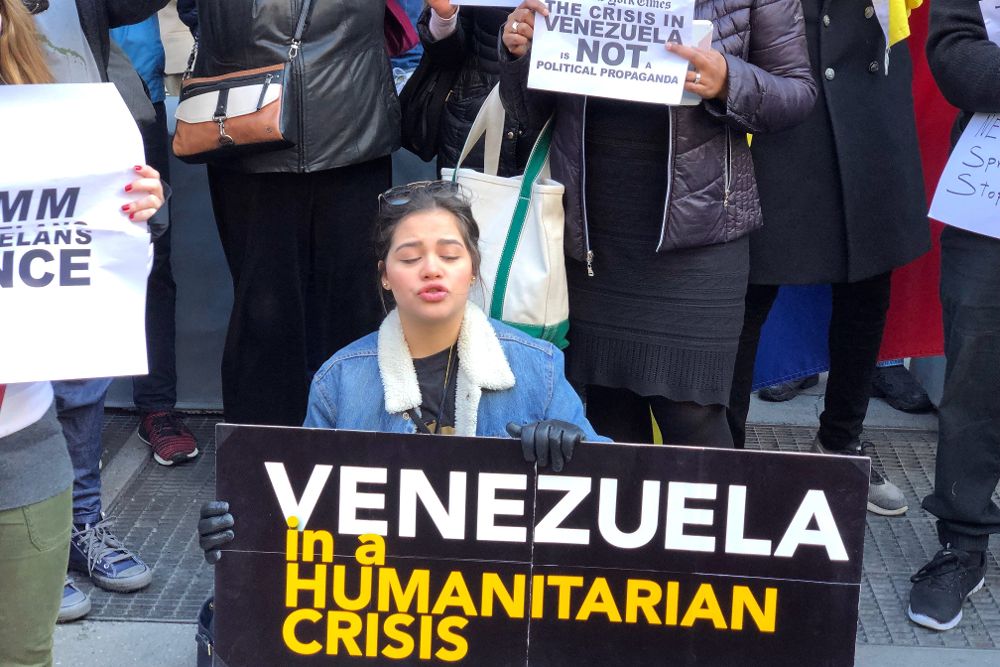 Un grupo de venezolanos sostiene pancartas con frases referentes a la crisis en Venezuela durante una manifestación frente al edificio de The New York Times, en Nueva York (EE.UU.). 